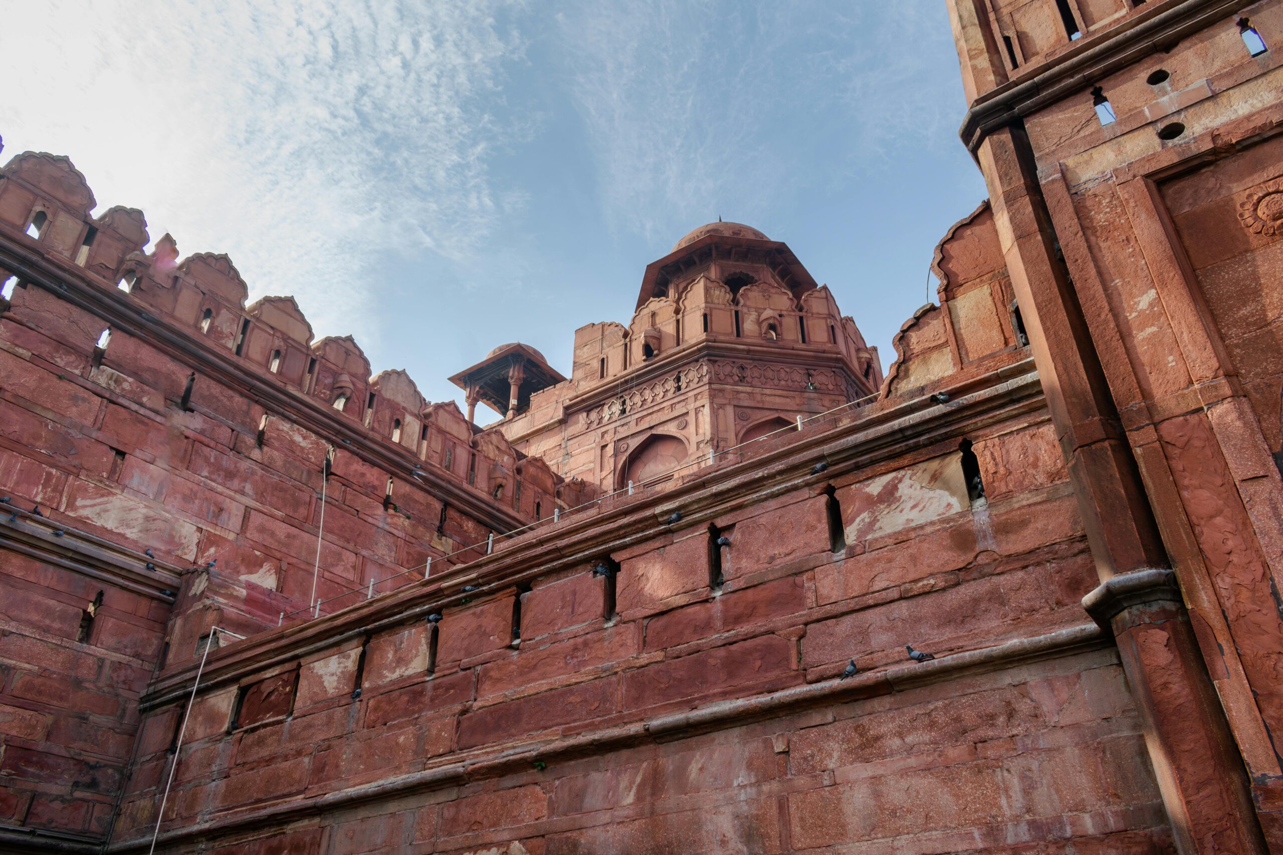 An impressive low-angle view of the Red Fort's historic Mughal architecture in Delhi, India.
